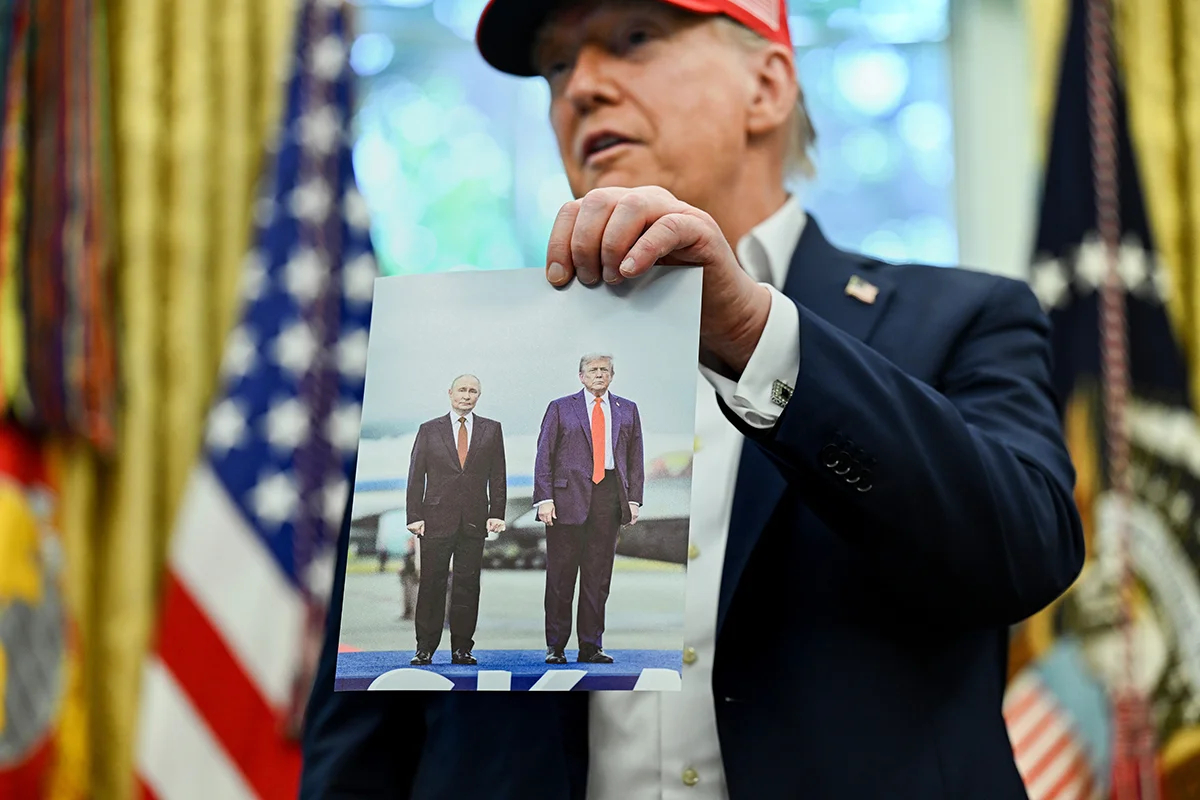 Президент США Дональд Трамп держит в руках свою фотографию с Владимиром Путиным на Аляске, овальный кабинет Белого дома в Вашингтоне, округ Колумбия, США, 22 августа 2025 года. Фото: Annabelle Gordon / EPA