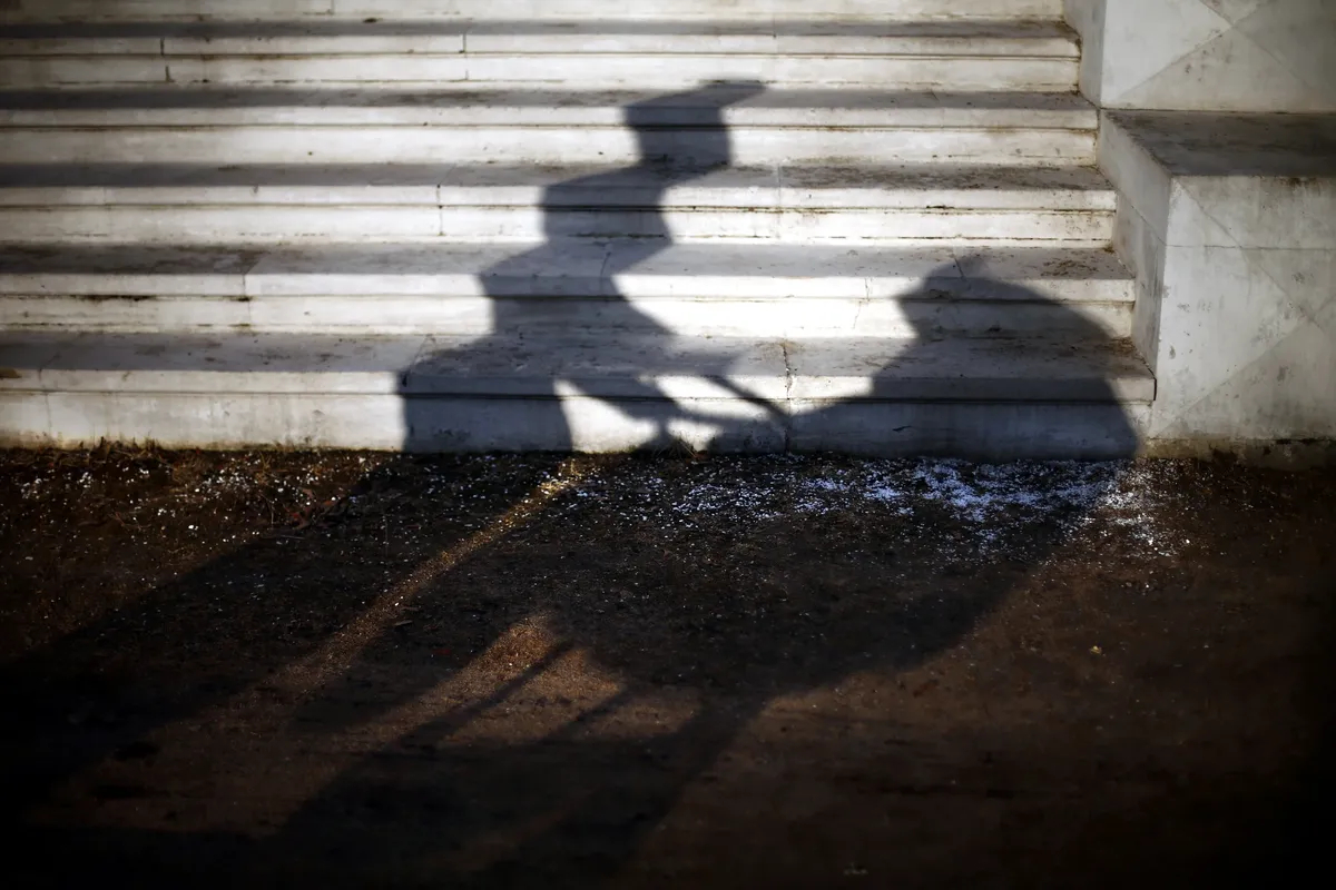 The shadow of a woman pushing a stroller through Moscow’s Ostafyevo Park. Photo: EPA / MAXIM SHIPENKOV