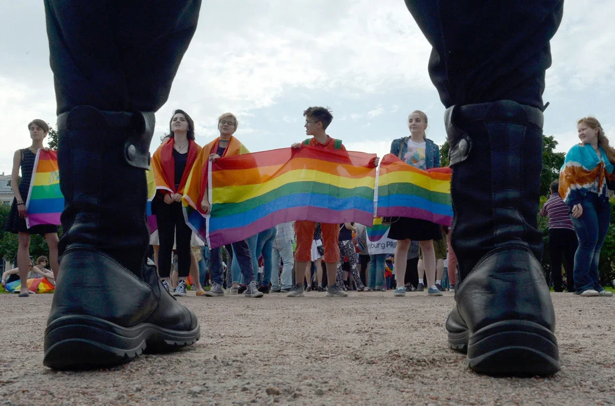 Pride participants in St. Petersburg hold a rainbow flag as police stand opposite in the background, August 12, 2017. Photo: Olga Maltseva / AFP / Scanpix / LETA