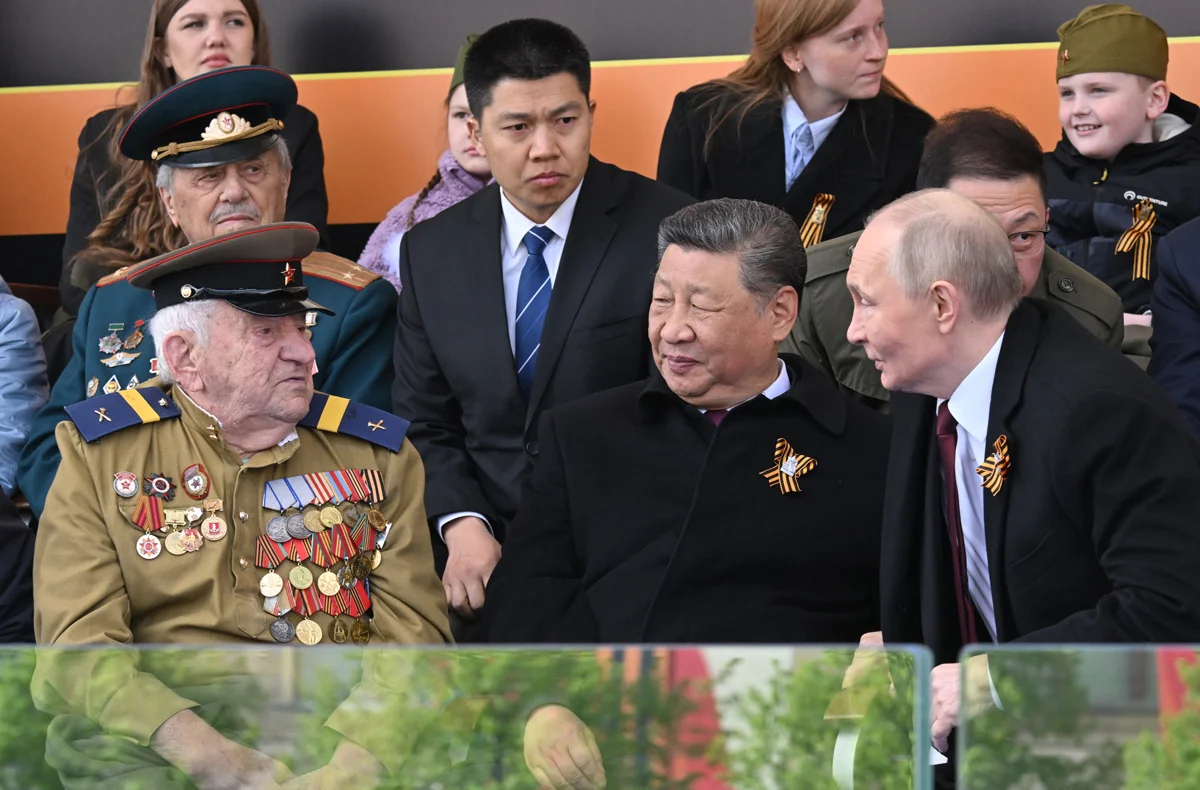 Владимир Путин и председатель КНР Си Цзиньпин с зрителями парада на Красной площади, Москва, 9 мая 2025 года. Фото: Илья Питалев / РИА Новости / EPA