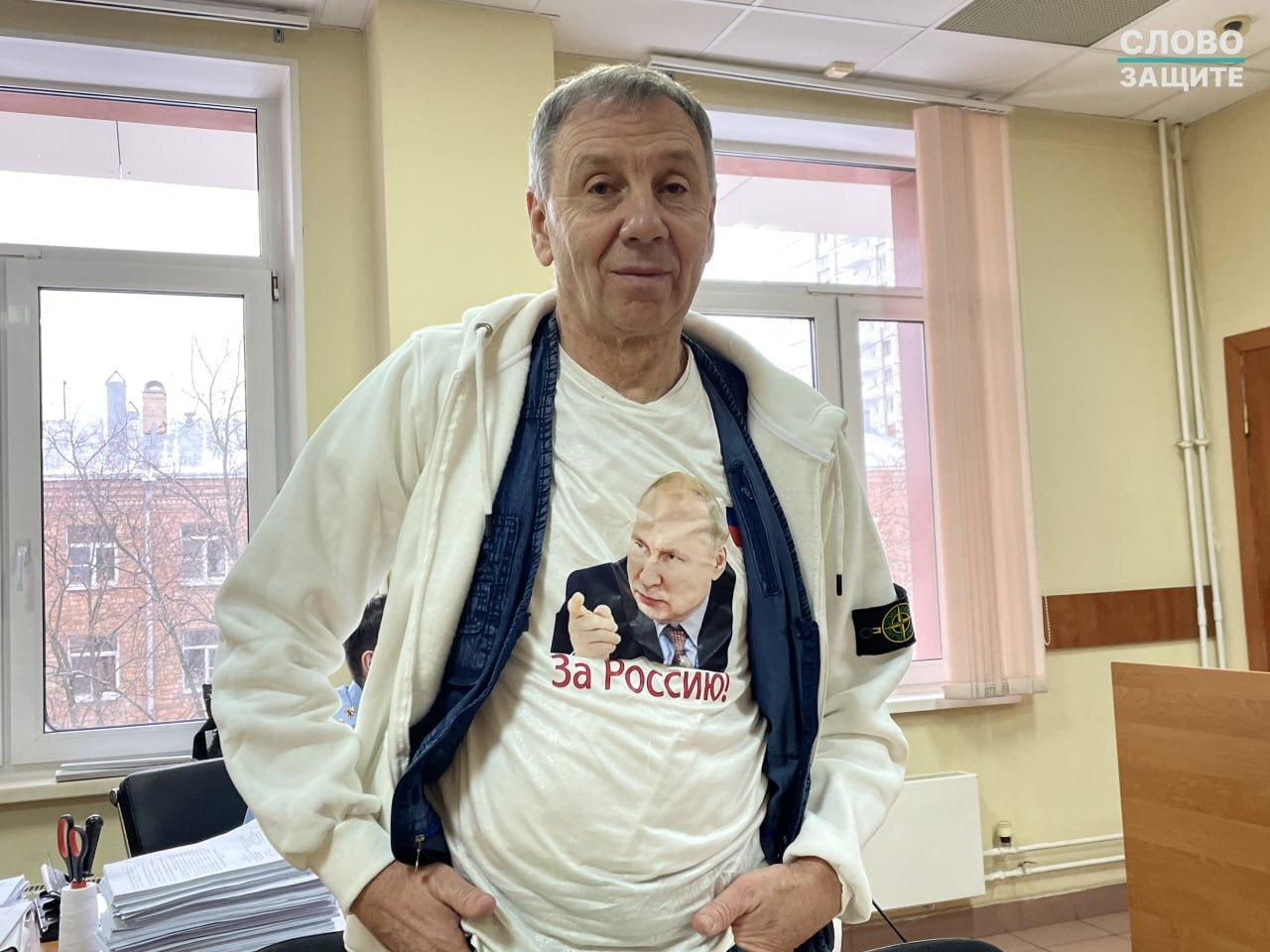 Политолог Сергей Марков в футболке с изображением Владимира Путина в суде, Москва, декабрь 2025 года. Фото: Слово защите / Telegram