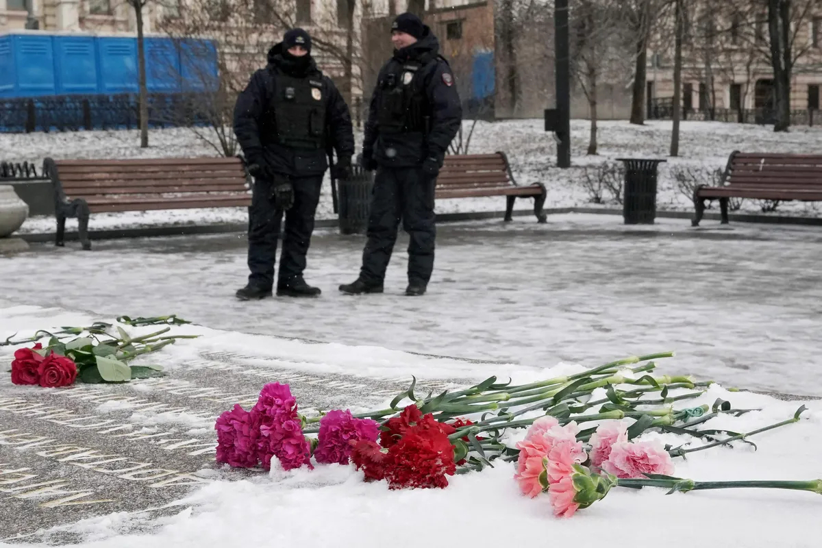 Полицейские дежурят у Соловецкого камня — памятника жертвам политических репрессий, пока люди отдают дань памяти Алексею Навальному, Москва, 16 февраля 2025 года. Фото: Татьяна Макеева / AFP / Scanpix / LETA