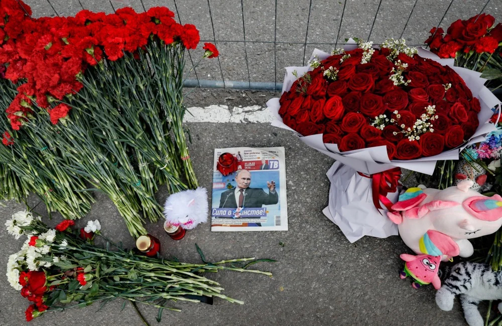 A newspaper and flowers at Crocus City Hall after the attack in Krasnogorsk, outside Moscow, 28 March 2024. Photo: EPA-EFE/YURI KOCHETKOV