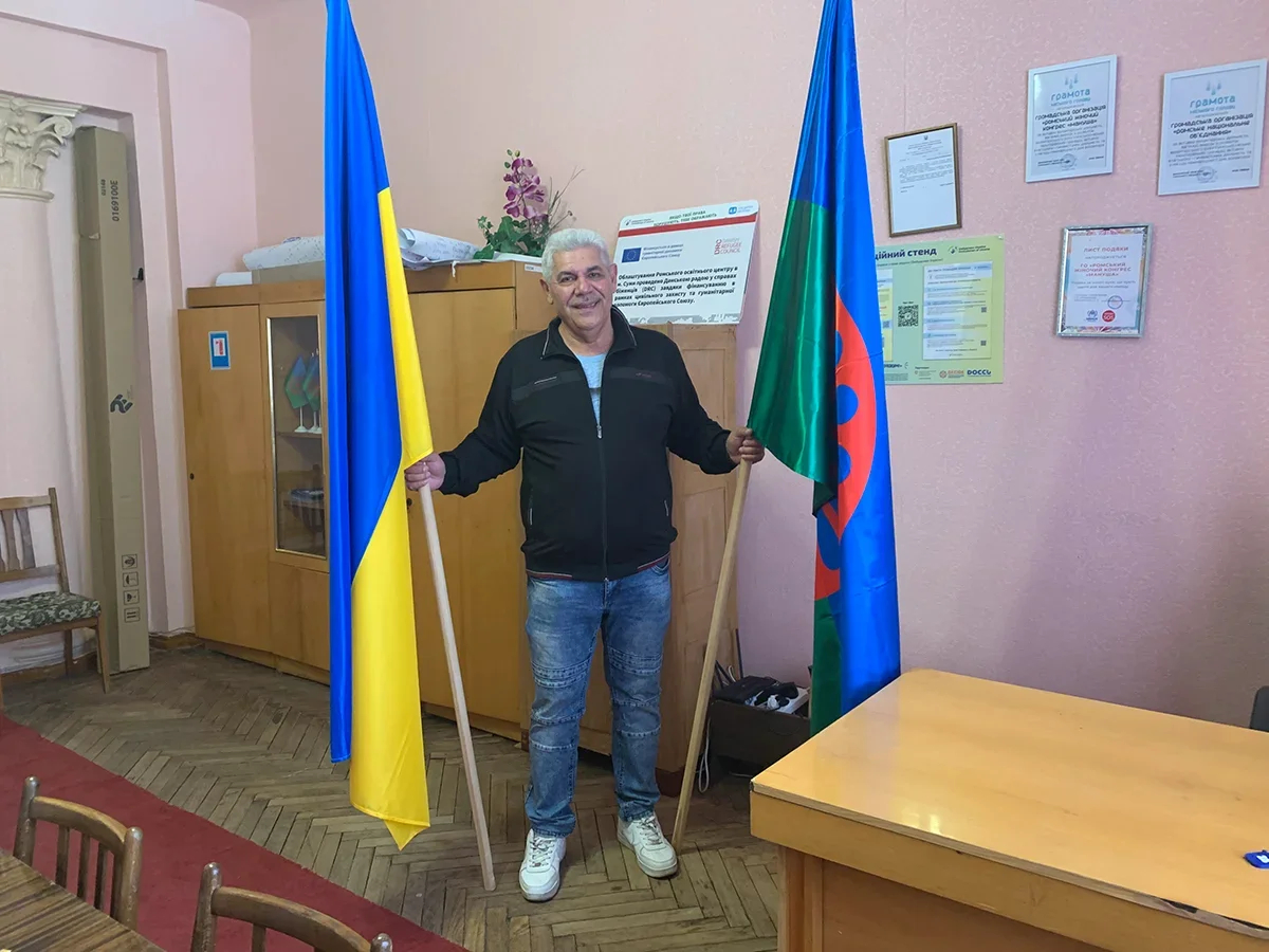 Mykola Moskalyov at the National Roma Association office, with Ukrainian and Romani flags. Photo: Olga Musafirova