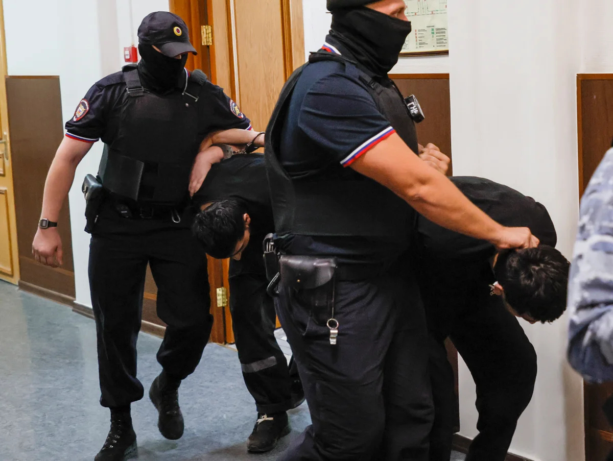 Сотрудники полиции сопровождают обвиняемых по делу о теракте в Crocus City Hall перед заседанием Басманного суда, Москва, 19 августа 2024 года. Фото: Юрий Кочетков / EPA