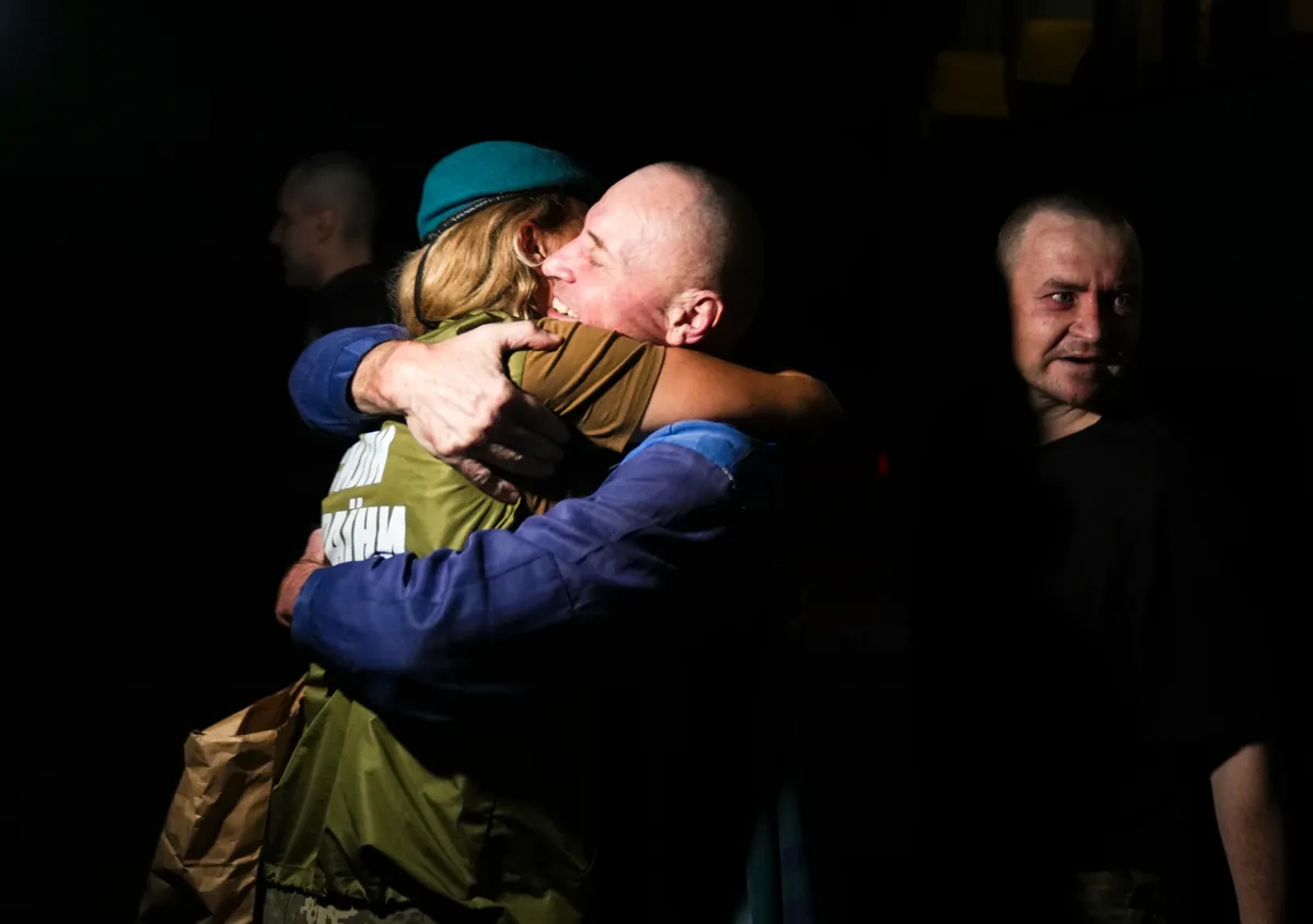 A Ukrainian prisoner of war is embraced following a prisoner swap at an undisclosed location in Ukraine, 23 July 2025. Photo: EPA/STRINGER