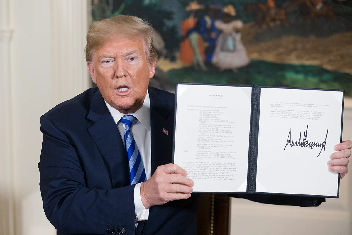 Президент США Дональд Трамп держит в руках президентский меморандум по национальной безопасности в отношении Ирана, который он только что подписал в дипломатической приемной Белого дома в Вашингтоне, округ Колумбия, США, 8 мая 2018 года. Фото: Michael Reynolds / EPA-EFE
