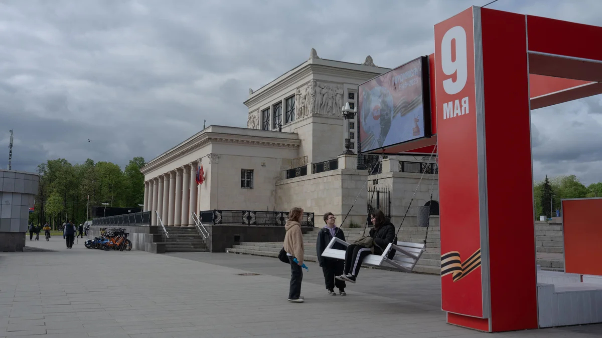 Декорированные качели у метро «Динамо». На экране демонстрируется военная хроника и плакаты.