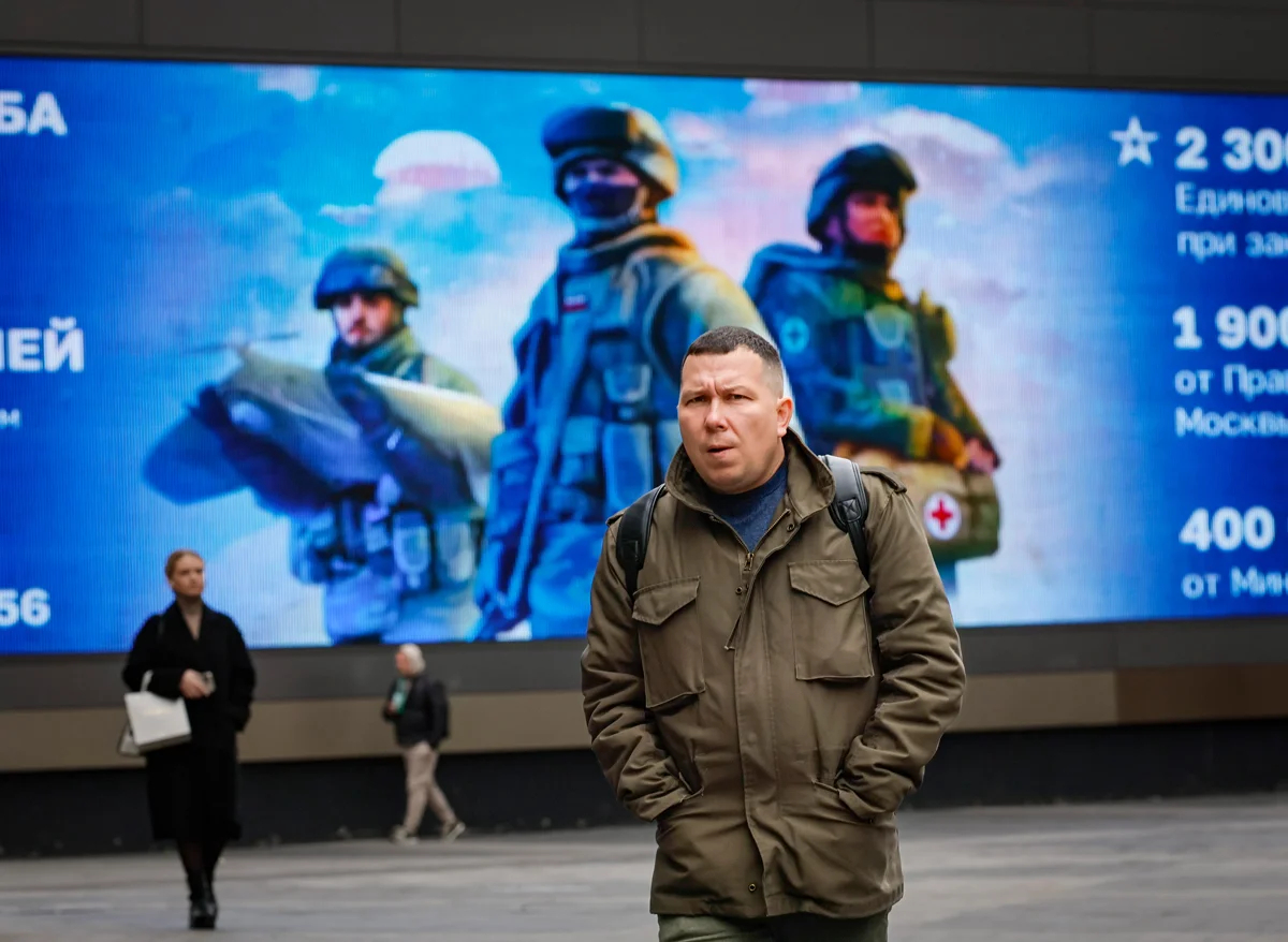 Прохожий на фоне рекламы военной службы возле Киевского вокзала в Москве, 10 октября 2024 года. Фото: Юрий Кочетков / EPA
