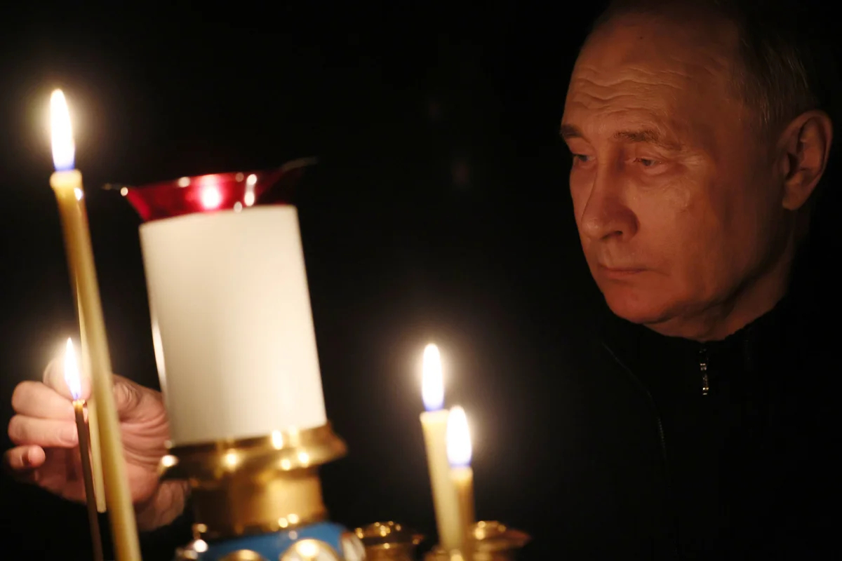 Владимир Путин зажигает свечу в память о жертвах теракта в Crocus City Hall , 24 марта 2024 года. Фото: Михаил Мецель / Спутник / Kremlin / EPA