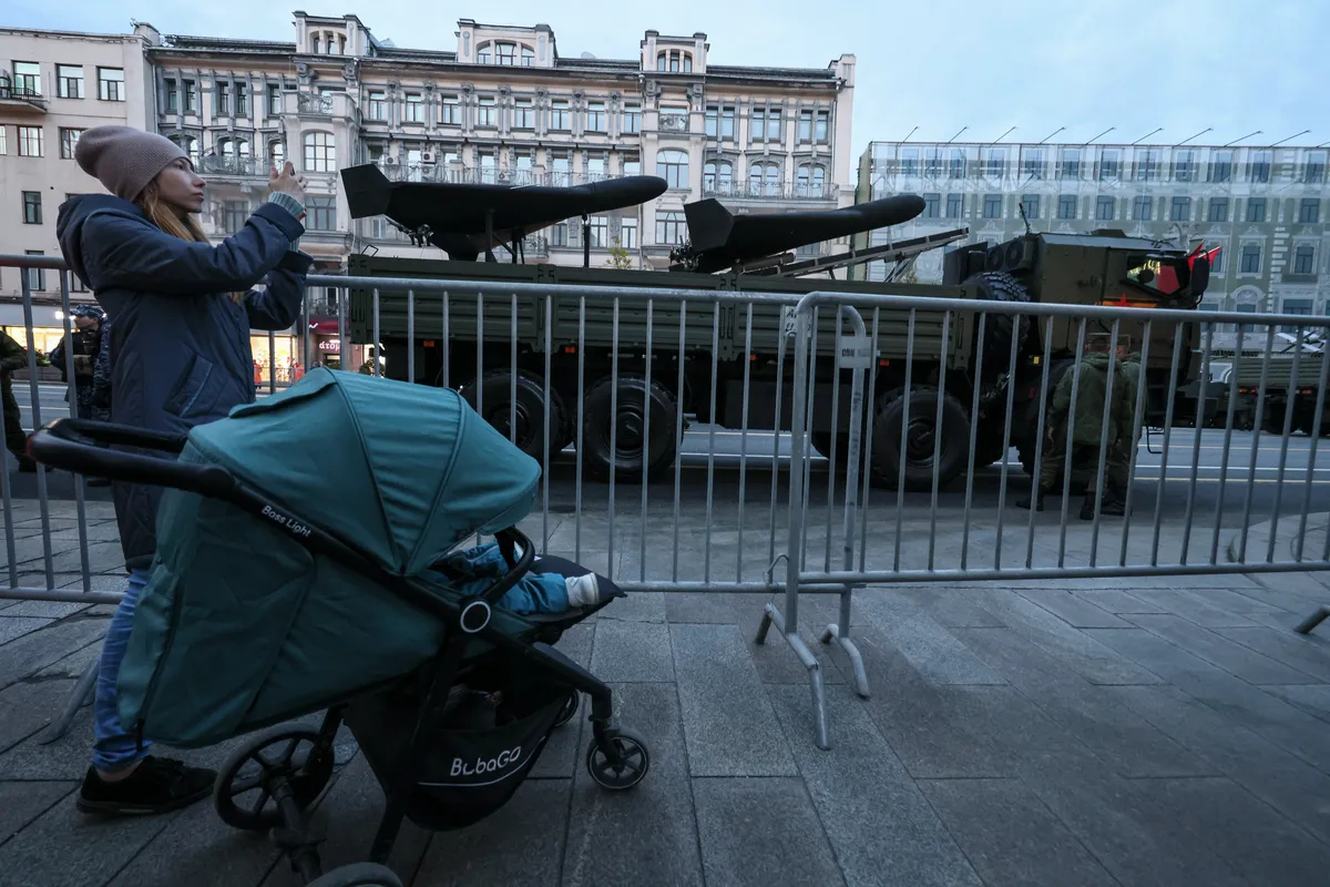 A woman watches Russian military drones taking part in celebrations for Victory Day in Moscow, 3 May 2025. Photo: EPA-EFE / SERGEI ILNITSKY