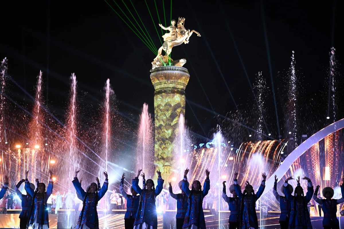 Танцоры во время концерта на фоне статуи Гурбангулы Бердымухамедова в городе Аркадаг, названном в его честь, Туркменистан, 29 июня 2023 года. Фото: Наталья Колесникова / AFP / Scanpix / LETA