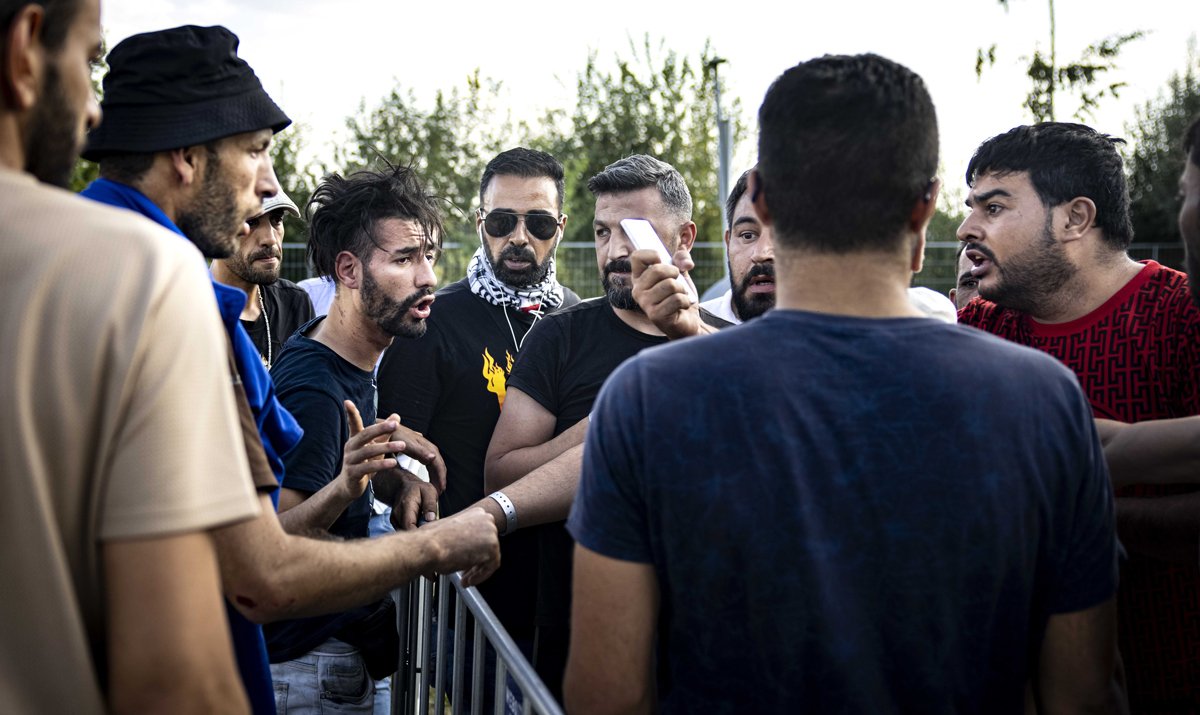 Мигранты у входа в центр для беженцев в Тер-Апеле, Нидерланды, 14 августа 2022 года. Фото: Ramon Van Flymen / EPA