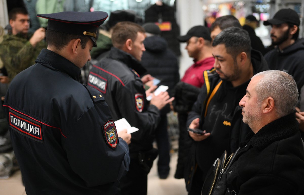 Полицейские проверяют документы сотрудников торгового центра во время рейда по выявлению нарушителей миграционного законодательства и правил воинского учёта в Новосибирске, 15 октября 2024 года. Фото: Александр Кряжев / Спутник / Imago Images / Scanpix / LETA