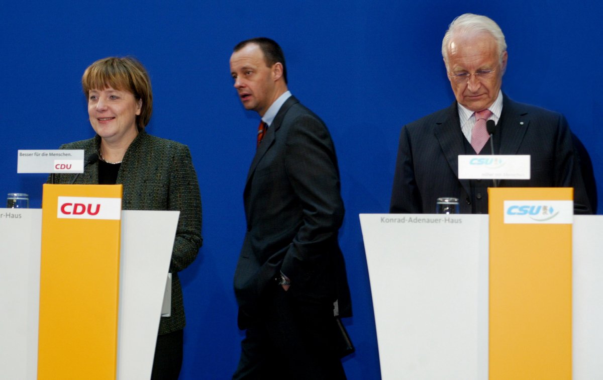 Фридрих Мерц (в центре) проходит за председателем ХДС Ангелой Меркель (слева) и премьер-министром Баварии, лидером ХСС Эдмундом Штойбером, Берлин, 8 марта 2004 года. Фото: Michael Urban / ddp / Vida Press