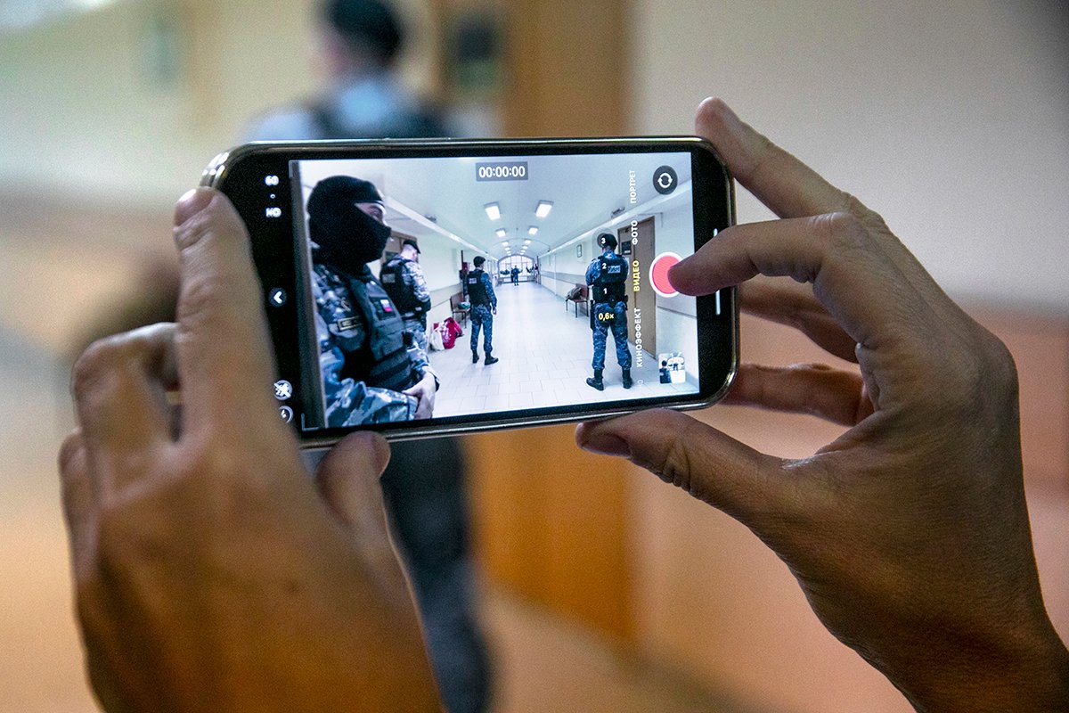 Слушатель судебного заседания снимает на смартфон судебных приставов. Фото: Дмитрий Цыганов