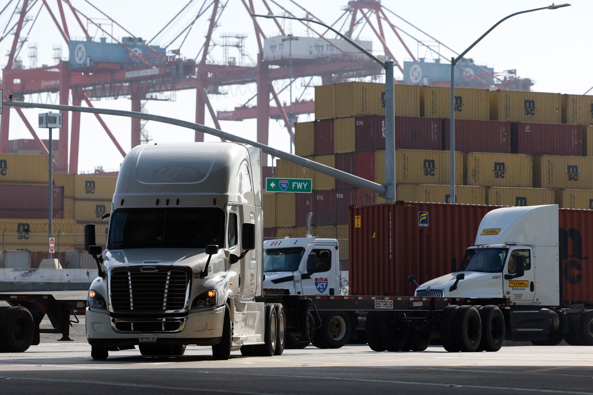 Грузовики проезжают мимо контейнеров в порту Лос-Анджелеса, Калифорния, США, 3 февраля 2025 года. Фото: Caroline Brehman / EPA