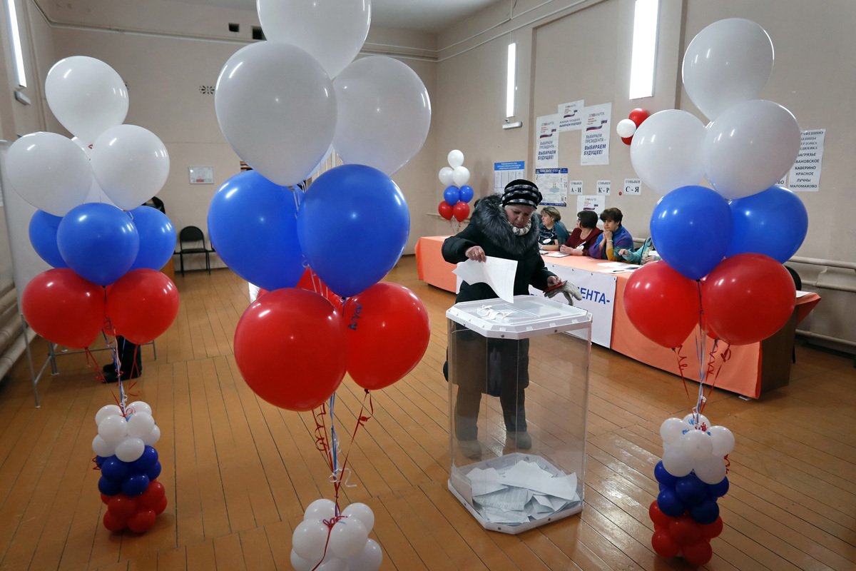 Женщина голосует на избирательном участке во время президентских выборов в Калужской области, Россия, 18 марта 2018 года. Фото: Юрий Кочетков / EPA-EFE