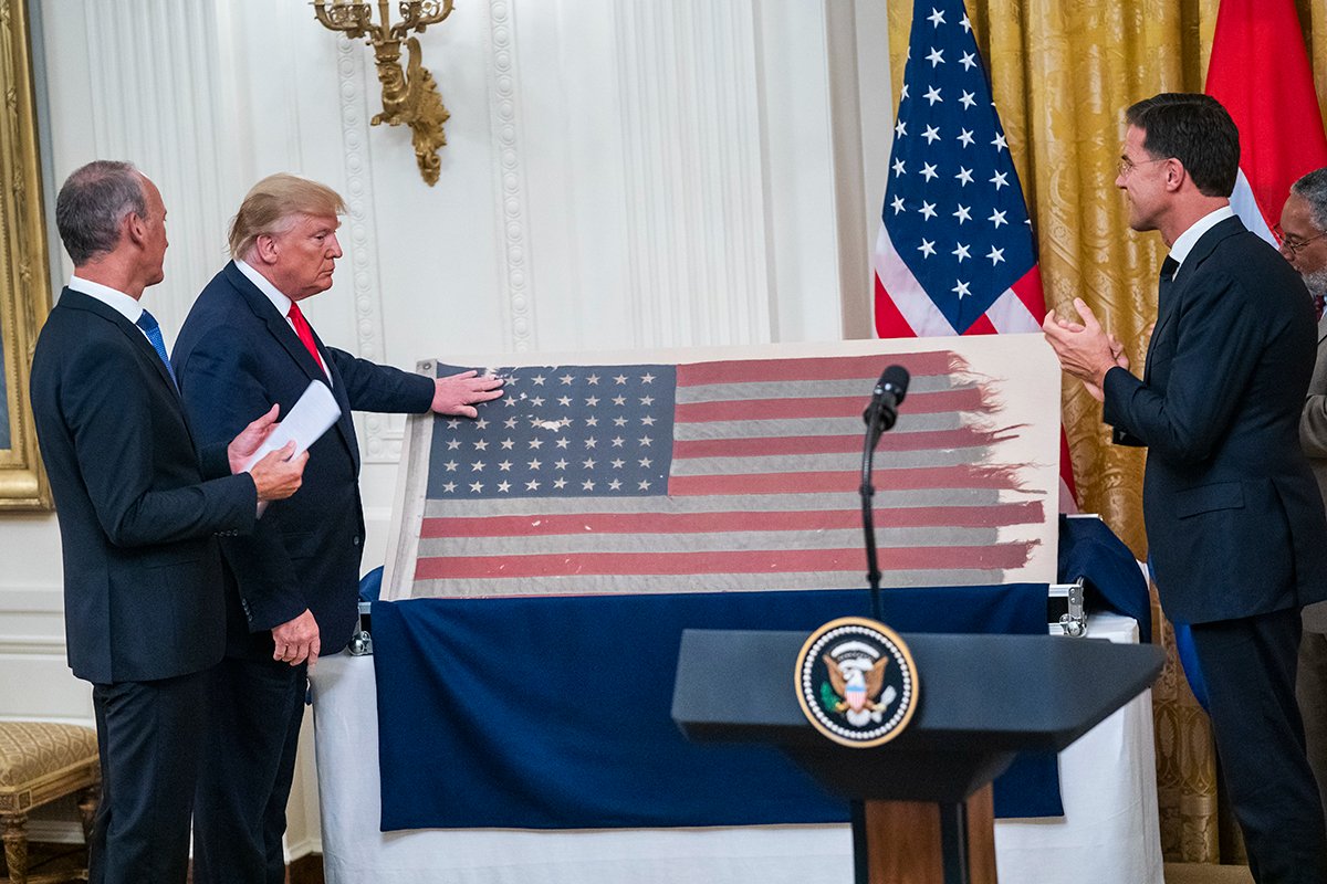 Дональд Трамп принимает от премьер-министра Нидерландов Марка Рютте принадлежащий Нидерландам американский флаг с корабля военно-морских сил в день «Д», Вашингтон, округ Колумбия, США, 18 июля 2019 года. Фото: Jim Lo Scalzo / EPA-EFE
