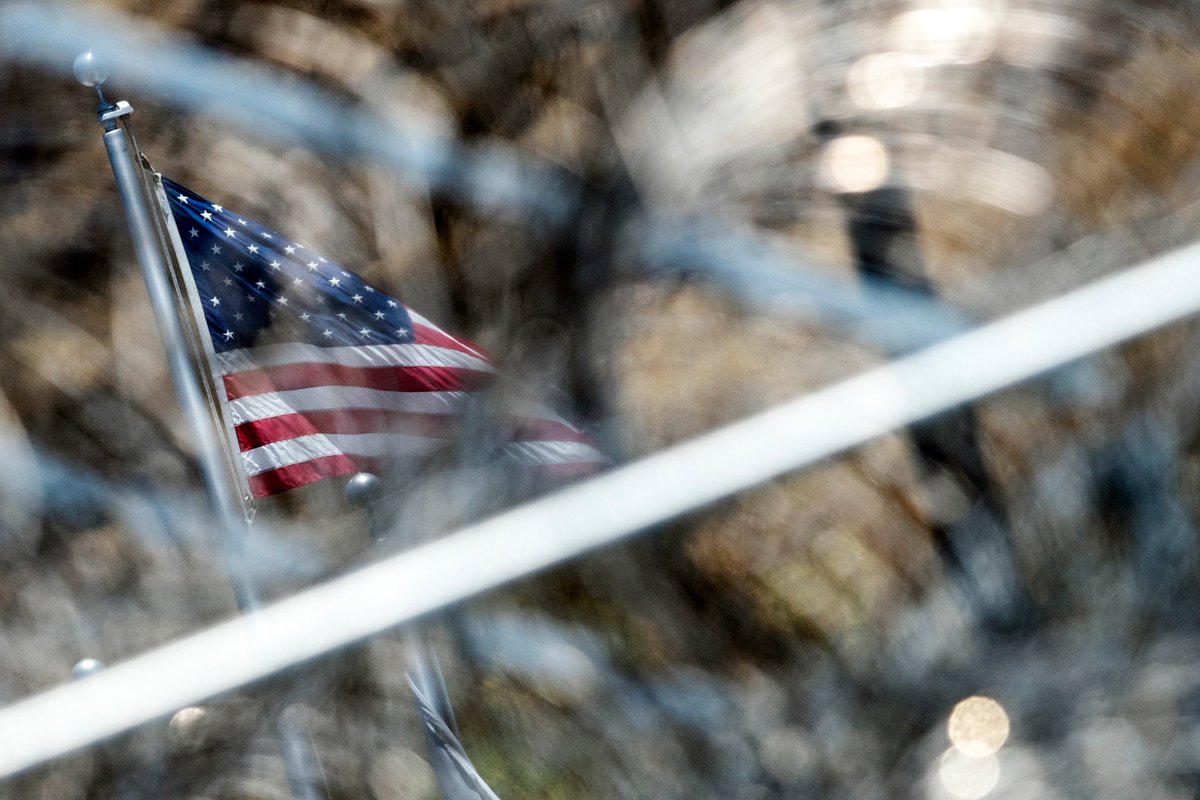 Флаг США за колючей проволокой центра содержания мигрантов в Сан-Диего, Калифорния, США, 2 июля 2018 года. Фото: Etienne Laurent / EPA