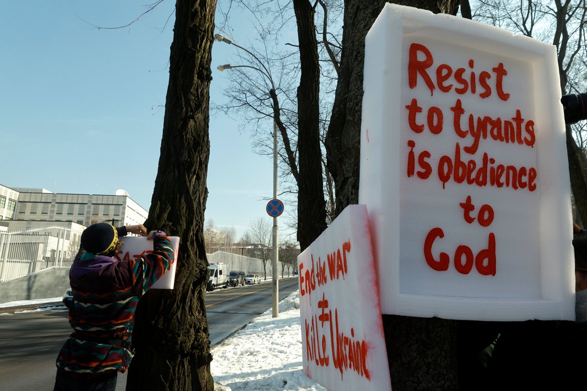 Один из участников акции вешает плакаты на деревья. Фото: Sergey Dolzhenko / EPA