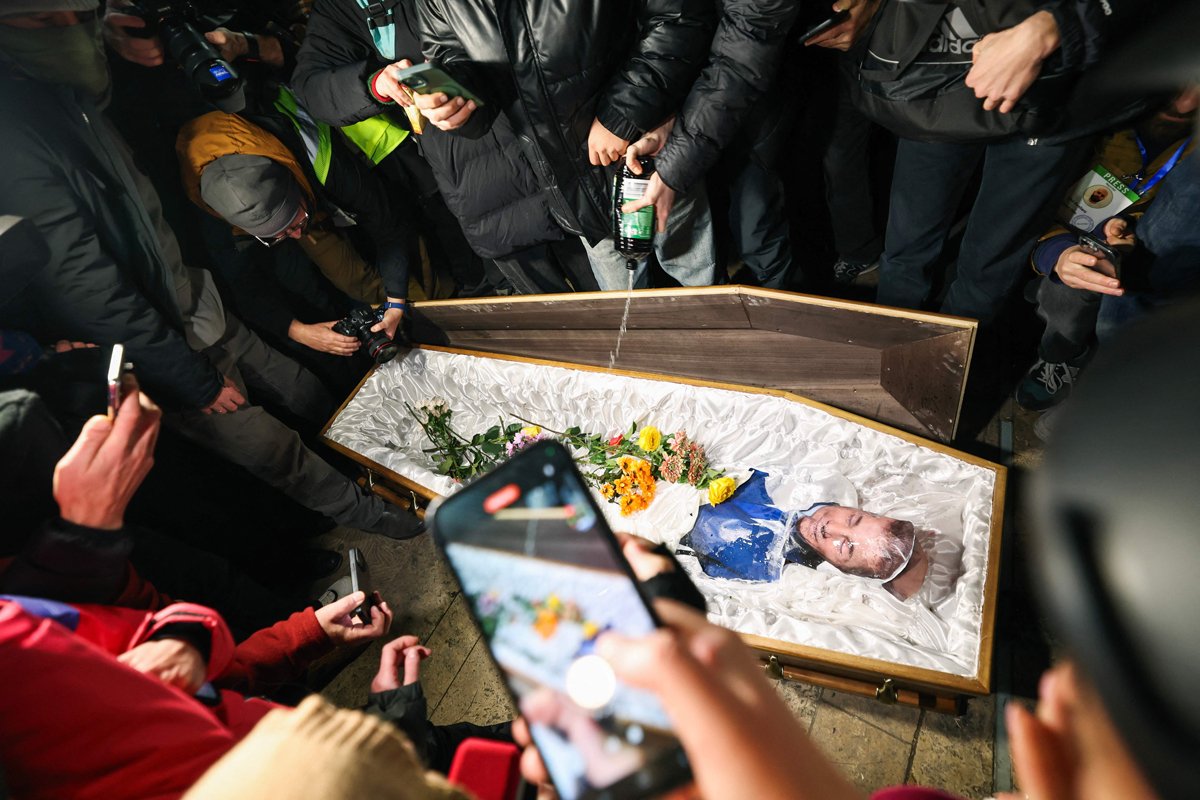 Демонстранты выливают горючую жидкость в гроб с изображением Бидзины Иванишвили на акции протеста в Тбилиси, 9 декабря 2024 года. Фото: Giorgi Arjevanidze / AFP / Scanpix / LETA