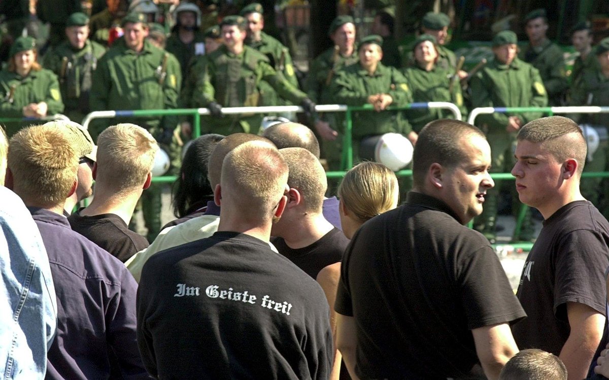 Члены неонацистской Национал-демократической партии Германии (НДПГ) напротив шеренги полицейских во время митинга НДПГ во Фрайбурге, 14 сентября 2002 года. Фото: Patrick Seeger / EPA / DPA