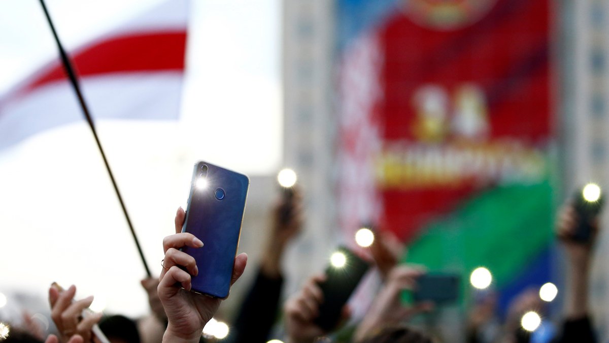 Протестующая стоит перед белорусскими полицейскими, перекрывающими дорогу во время антиправительственного митинга в Минске, Беларусь, 25 октября 2020 года. Фото: EPA