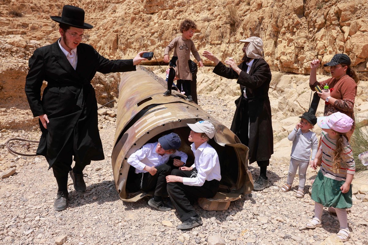 Ультраортодоксальные евреи у обломков иранской баллистической ракеты, сбитой Израилем, в пустыне Негев возле города Арад, 30 апреля 2024 года. Фото: Menahem Kahana / AFP / Scanpix / LETA