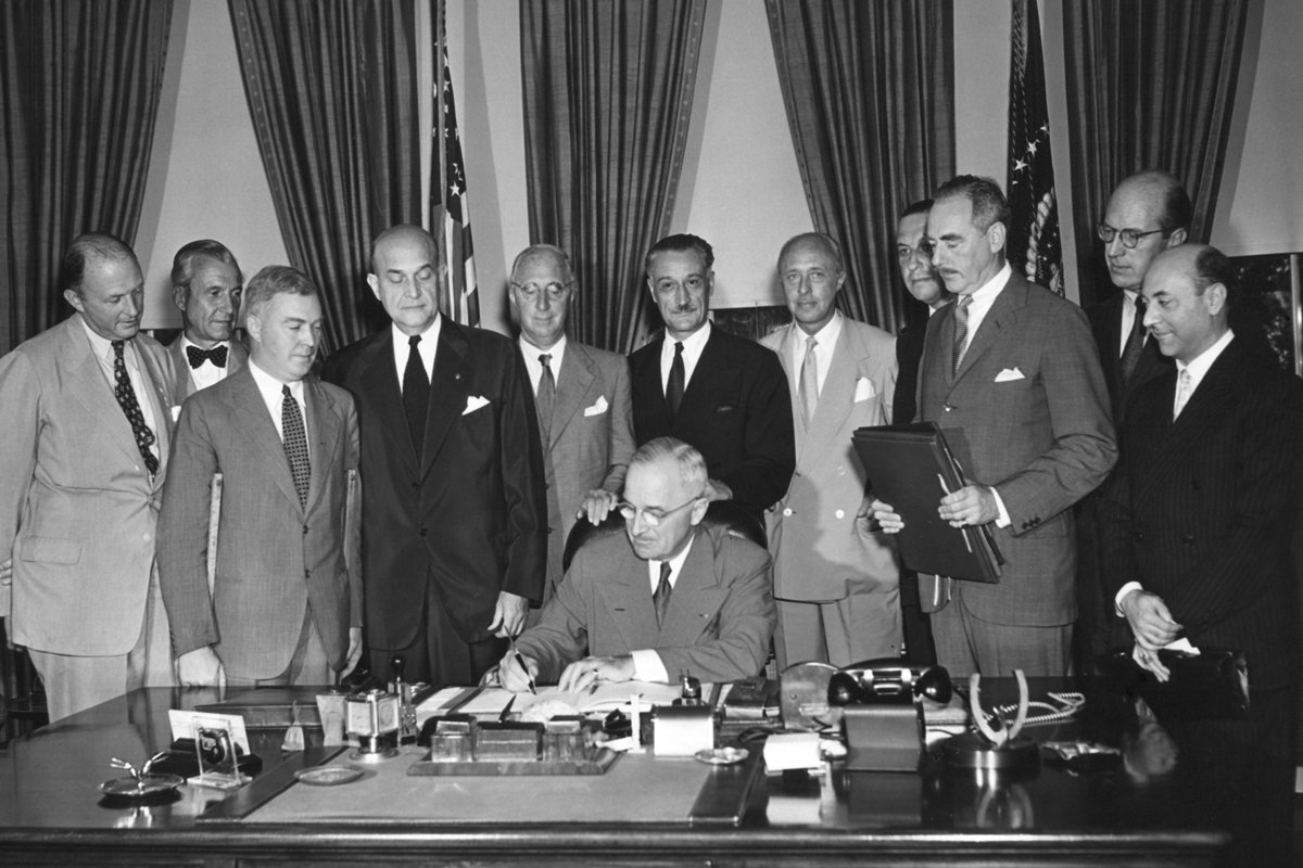 Президент США Гарри Трумэн в окружении дипломатов стран-участниц договора и американских официальных лиц подписывает Североатлантический договор, 24 августа 1949 года. Фото: Courtesy Everett Collection / Vida Press