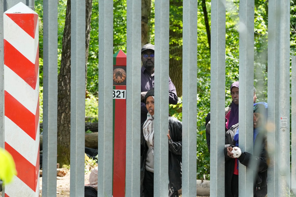 Мигранты за металлическим забором, построенным Польшей вдоль границы с Беларусью, Беловежская пуща, Польша, 29 мая 2024 года. Фото: Czarek Sokolowski / AP Photo / Scanpix / LETA